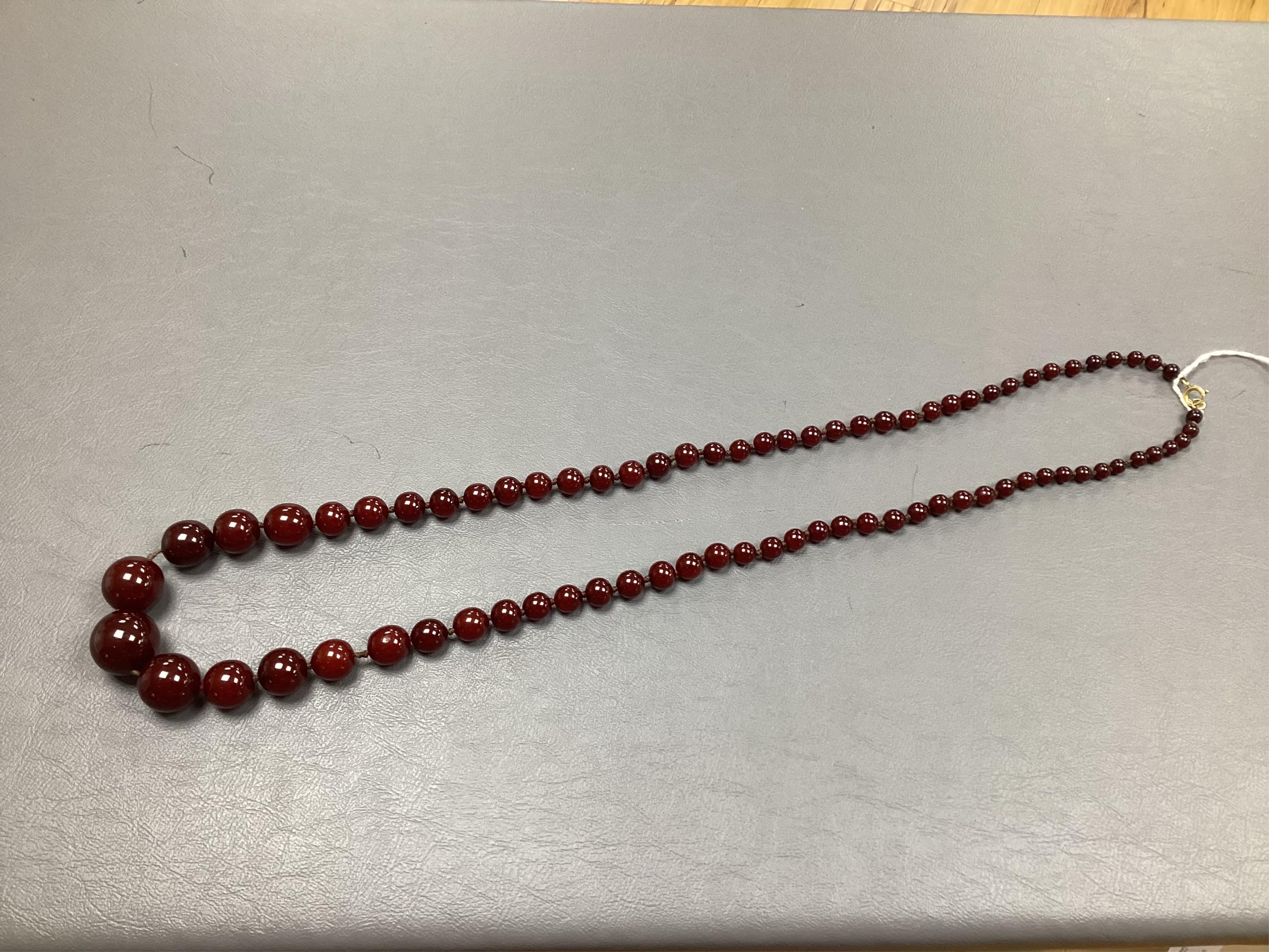 A cherry bakelite 'amber' necklace, composed of graduated spherical beads measuring approximately 6.7-23mm diameter, length approximately 86cm, gross weight 72 grams.